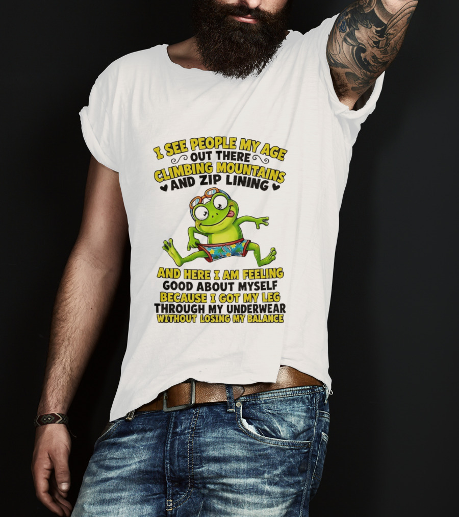 I See People My Age Climbing Mountains And Zip Lining Cartoon Frog Feeling Good Without Losing Balance T-Shirt