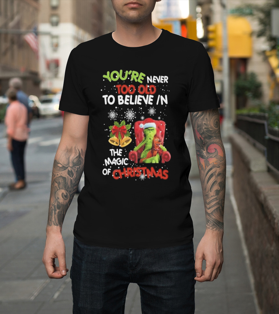 YOU'RE NEVER TOO OLD TO BELIEVE IN THE MAGIC OF CHRISTMAS GRINCH WITH MAX SITTING IN CHAIR SNOWFLAKES HOLIDAY BELLS AND BOW T-Shirt